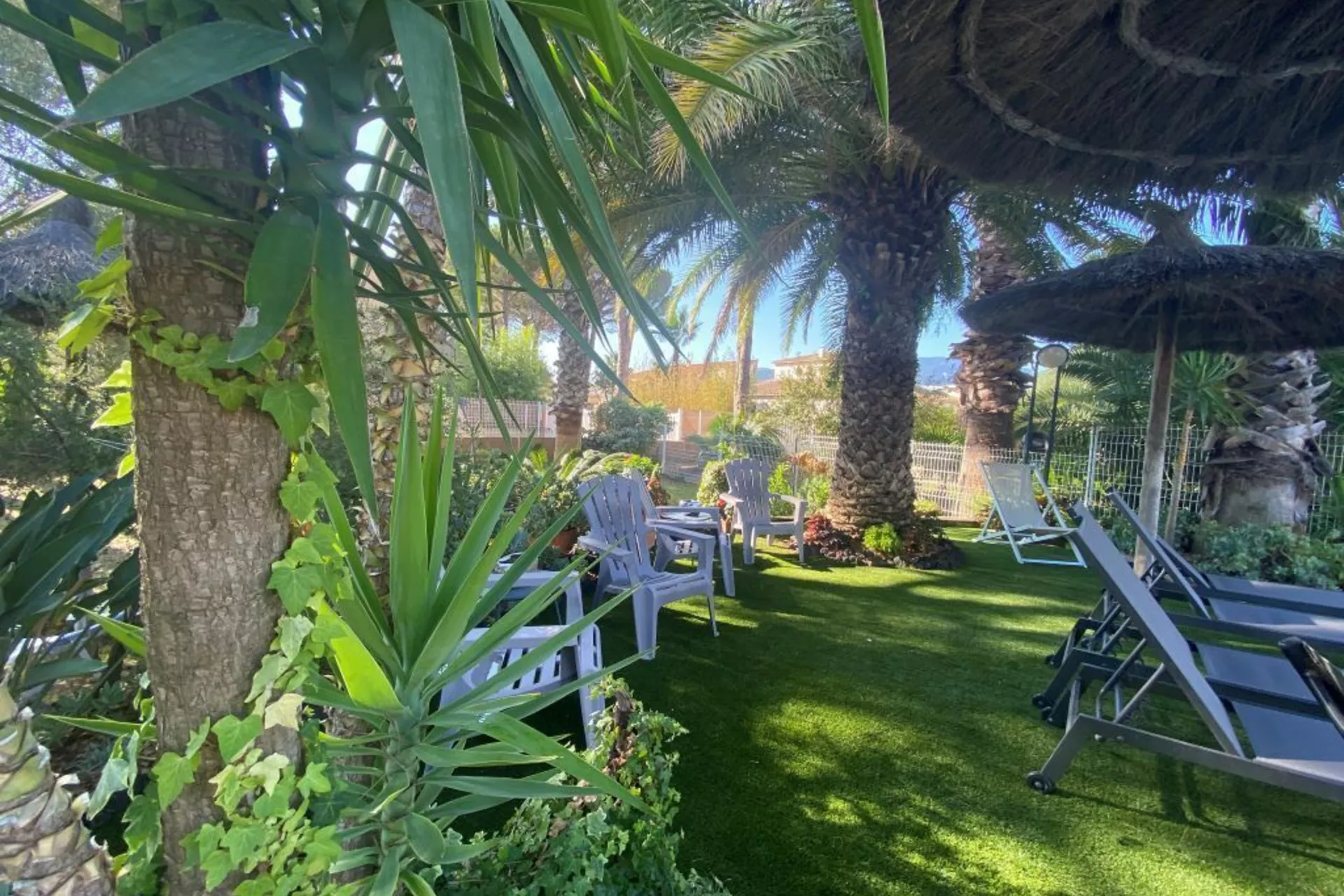 Petit coin détente côté piscine, Pelouse, arboré, fleuri, transats, parasol. Coin détente idéal pour profiter de ses vacances 